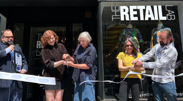 People cutting a ribbon outside The Retail Lab